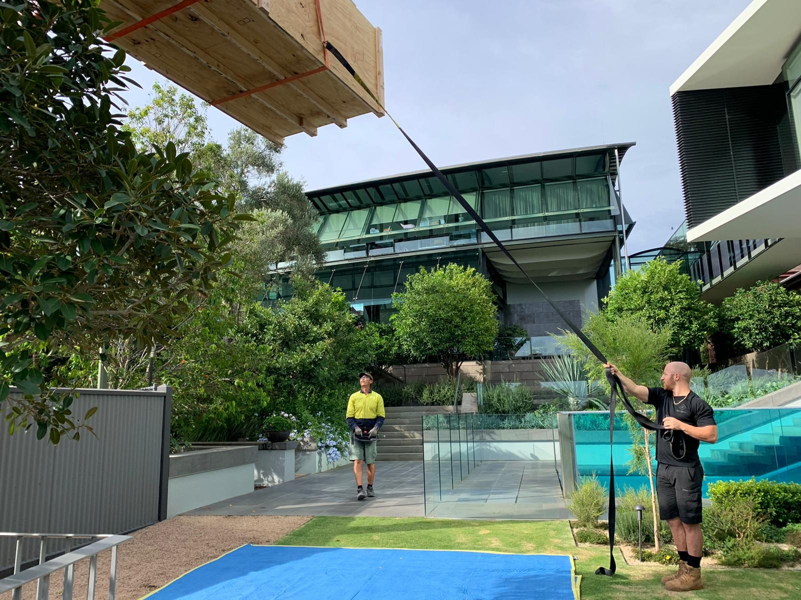 Craning a crated piece over a glass pool house