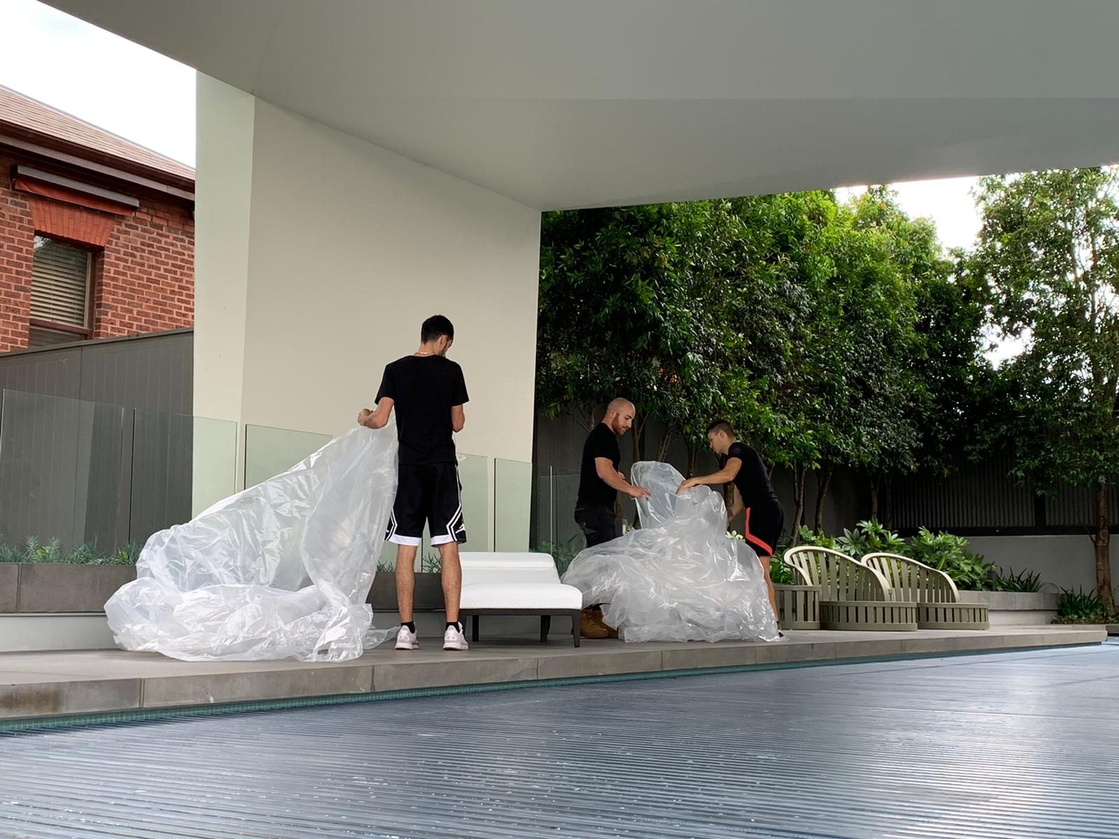 Crew protectively wrapping furniture on site